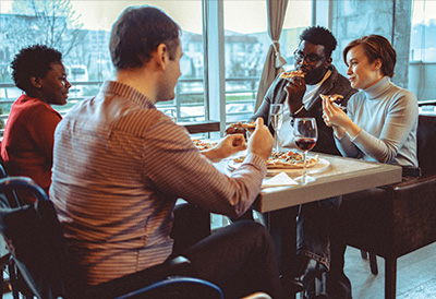 Evening Events Wheelchair user enjoys a evening meal with friends