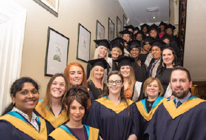 Home Care Training A group of graduates pose for the camera atop a stairs