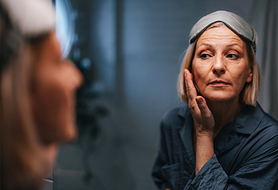 Hygiene, dressing, grooming and medication prompting Older woman with a facemask treating her face